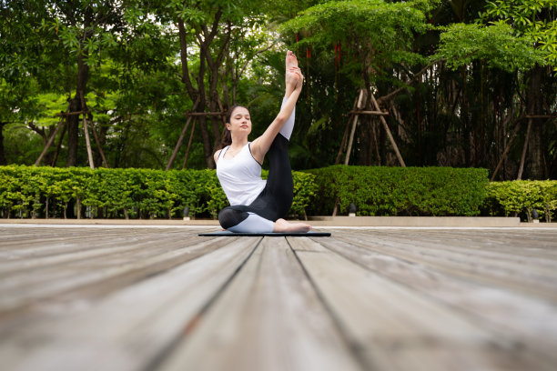 年轻女性在公园的木桥上进行健康的瑜伽活动图片下载