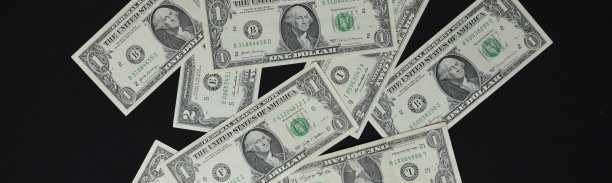 美钞在黑色的背景上杂乱地散落图片下载