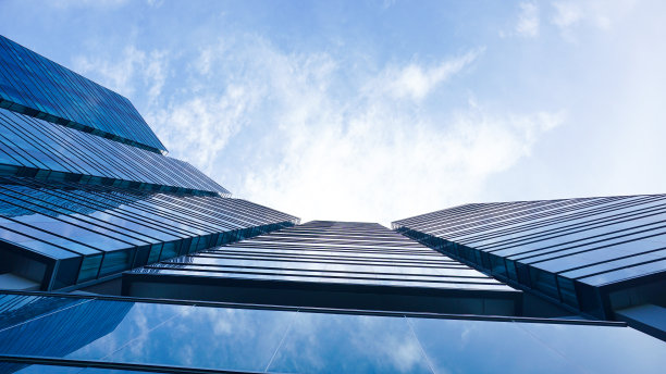 底部视图蓝色玻璃建筑与天空和云的背景。摩天楼，俯瞰现代商业大厦。天空景观与现代蓝色玻璃建筑。向上看。本空间图片下载