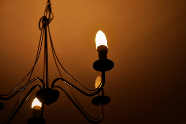 在黑暗的房间里发出柔和光线的一盏经典形状的灯。图片下载