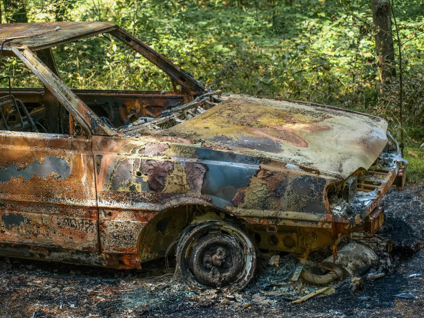 一辆被烧毁的旧汽车被遗弃在森林里的后世界末日照片图片下载