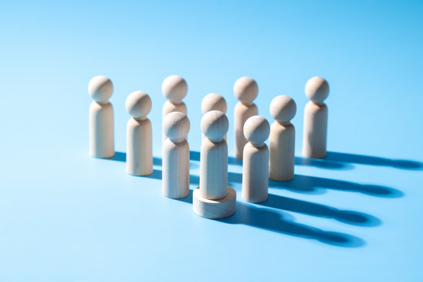 一个木制的商业团队标志。领导风格，战略合作概念。公司的一群员工。浅蓝色背景的木制标志。专业的商业团体。图片下载