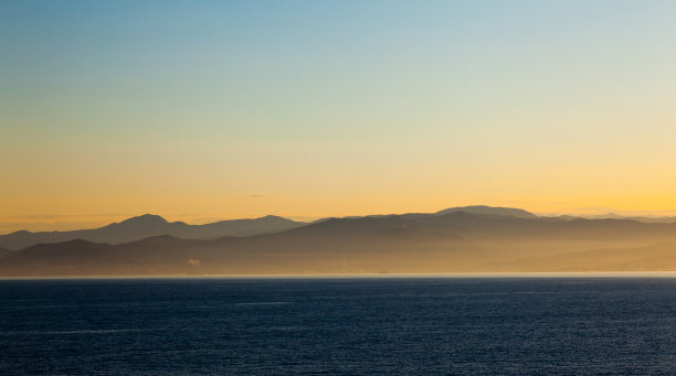 海，山在黄昏的雾中。图片下载