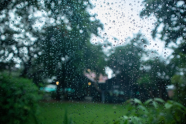 雨滴落在窗玻璃上，外面的纹理带有自然的背景图片下载