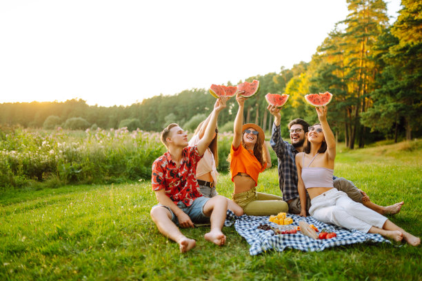 年轻人在户外野餐时吃西瓜。图片下载