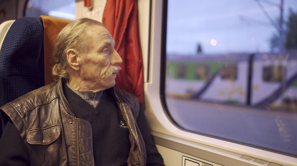 戴眼镜的老人在火车上看窗外的特写图片下载