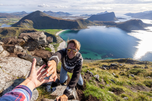 徒步旅行者帮助队友到达山顶图片下载