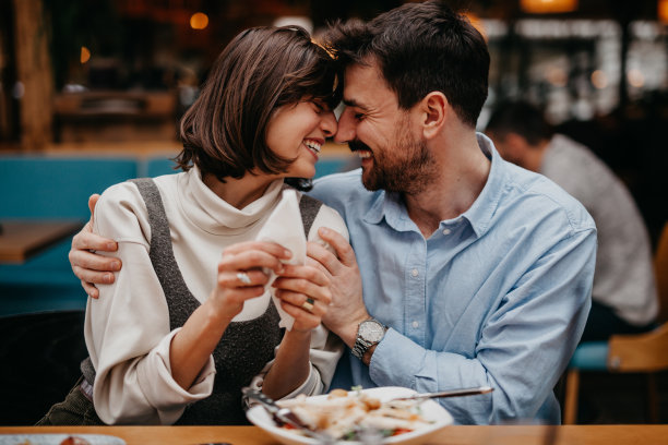 拍摄两个人在交谈，微笑，或分享一个轻松的时刻，同时享受他们的食物图片下载