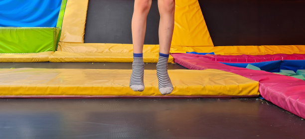 蹦床中心和孩子们的脚在蹦床上图片下载