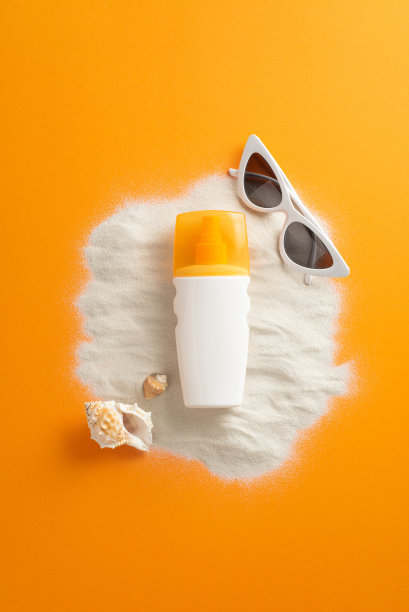 紫外线安全意识月高角度的照片，防晒乳液，白色太阳镜和海洋贝壳在沙滩上的橙色孤立的背景与复制空间图片下载