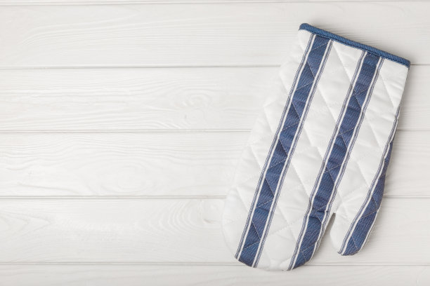 厨房用具。烤箱手套和锅托热菜在白色纹理木材。特写镜头。放文字的地方。副本的空间。图片下载