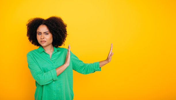 不高兴的巴西或非裔美国卷发妇女的全景照片显示拒绝的手势，拉开，看着相机鬼脸，站在孤立的黄色背景。Copy-space图片下载