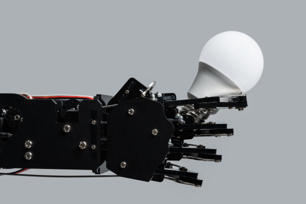 真正的机器人手持灯泡。人工智能发展和机器学习的概念。图片下载