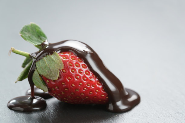 新鲜成熟的草莓与巧克力酱在石板背景图片下载