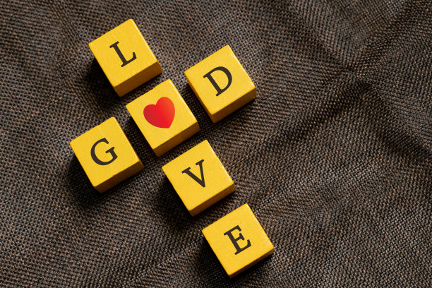 黑黑色背景上的红心，包括红心旁边的十字架。十字架是基督教的象征。上帝爱每个人，帮助所有的人。星期天去教堂祈祷和崇拜。图片下载