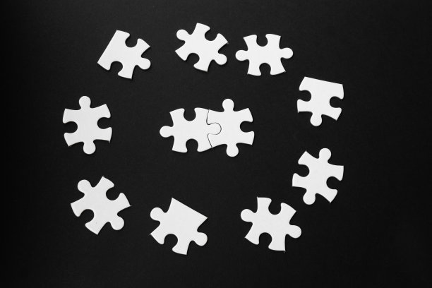 白色拼图片孤立在黑色背景。连接的概念。图片下载