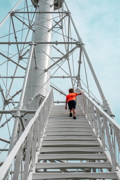 小男孩爬上佛罗里达州圣乔港一座独特的公共灯塔的楼梯;圣布拉斯角图片下载