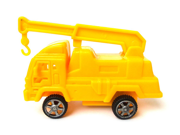 白色背景上孤立的黄色塑料起重机玩具特写。图片下载