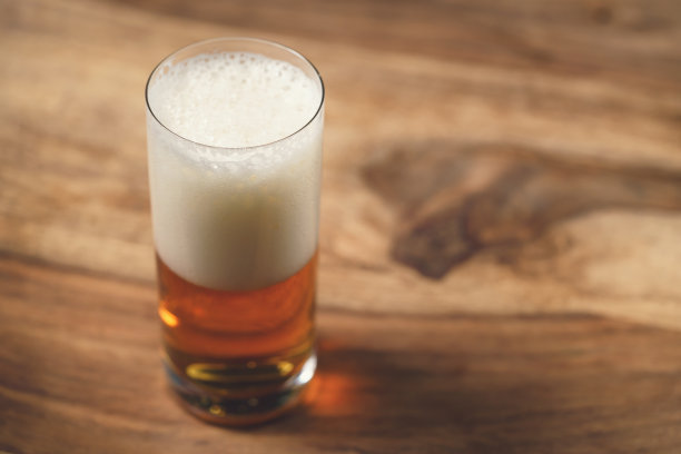 木板上的玻璃杯里装着啤酒图片下载