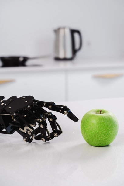 真正的机器人手和青苹果。人工智能发展和机器人过程自动化的概念。图片下载