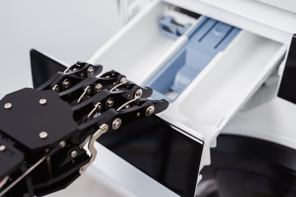 真正的机器人手和洗衣机。人工智能发展和机器人过程自动化的概念。图片下载