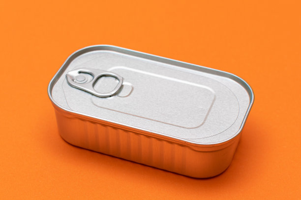 未开封的锡罐与空白边缘在橙色背景图片下载