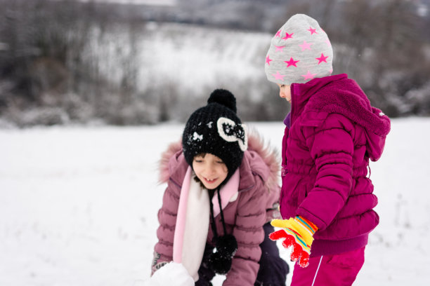 小姐妹们穿着粉色外套在雪地里玩耍的照片图片下载