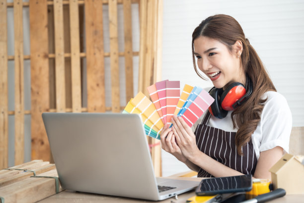 快乐的女木匠手拿潘通在她的车间。图片下载