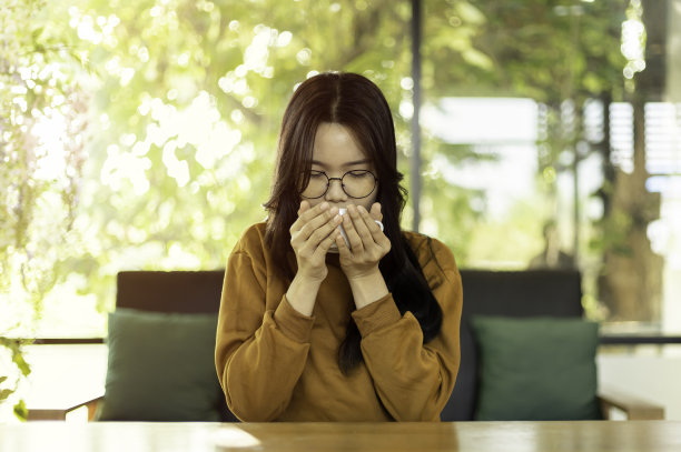 年轻亚裔女性在早晨阳光下喝热茶或咖啡图片下载