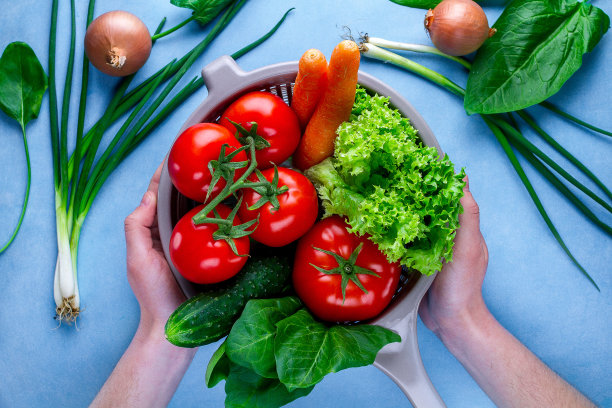 洗蔬菜。把干净、成熟的蔬菜放在滤锅里，用来做新鲜的沙拉。健康的食物和适当的营养。均衡的饮食图片下载