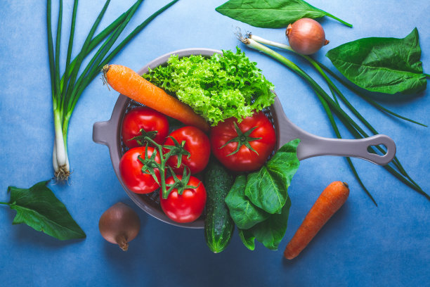 洗蔬菜。把干净、成熟的蔬菜放在滤锅里，用来做新鲜的沙拉。健康的食物和适当的营养。均衡的饮食图片下载