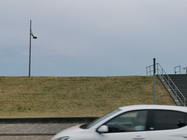 在不来梅港，开着一辆白色的汽车，背景是威瑟河堤图片下载