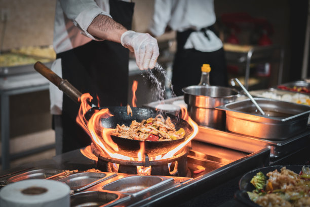 倒一些盐。专业厨师在厨房准备食物图片下载