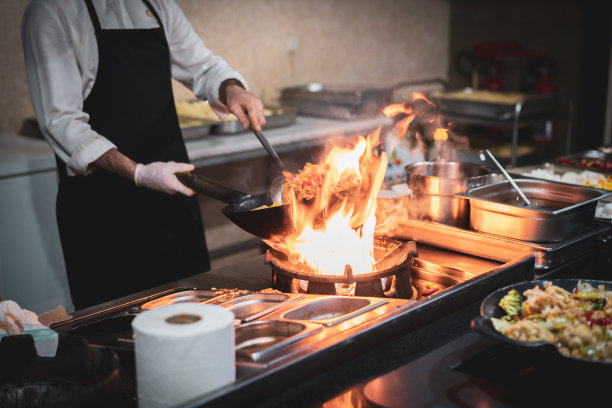 厨师在平底锅里用火煮虾和蔬菜图片下载