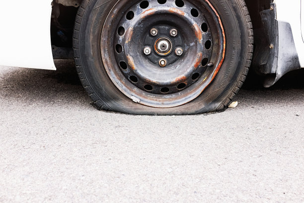 一辆停在城市街道上的废弃汽车爆胎，在柏油路上留下了复制空间图片下载