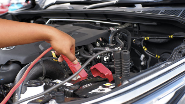 男子用跳线给汽车电池充电图片下载