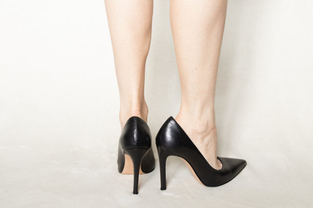 穿着黑色尖头高跟鞋的女孩站在家里的白色地毯上图片下载