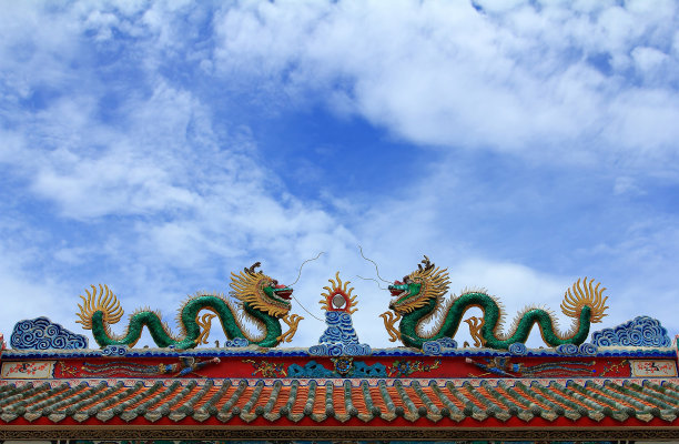 一座寺庙里的中国式龙像，两个绿色的龙像装饰着神社的屋顶图片下载