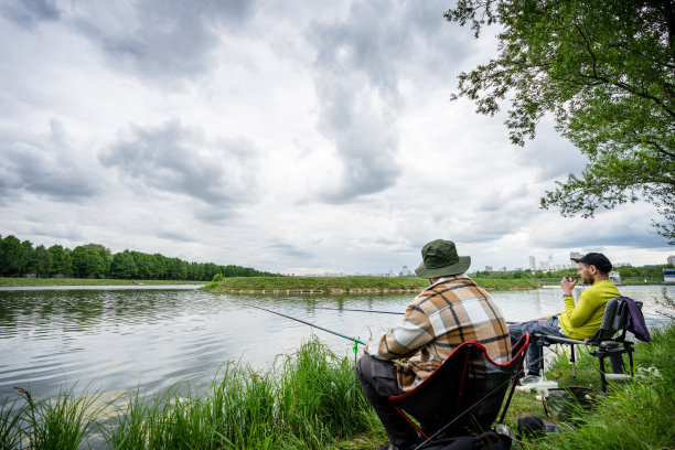 在水渠边钓鱼。两个人在市区钓鱼图片下载