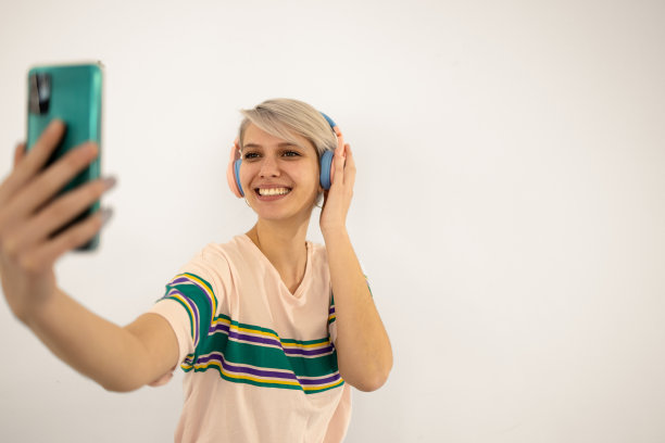 一个美丽的女孩听音乐和播客的工作室肖像图片下载