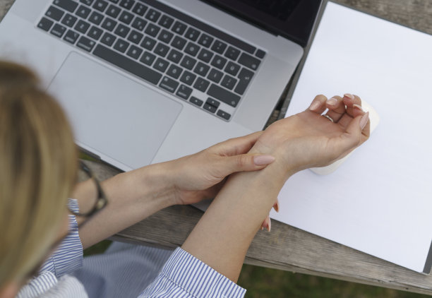 一位女商人因为使用笔记本电脑而痛苦地握着手腕图片下载