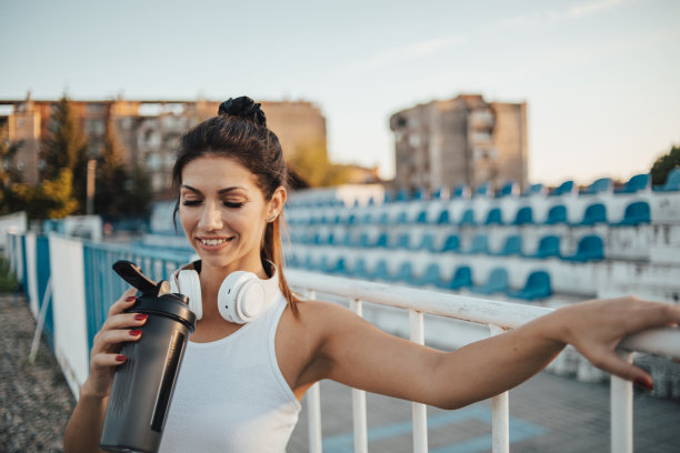 一位运动女性在户外训练和喝水后休息的画像图片下载