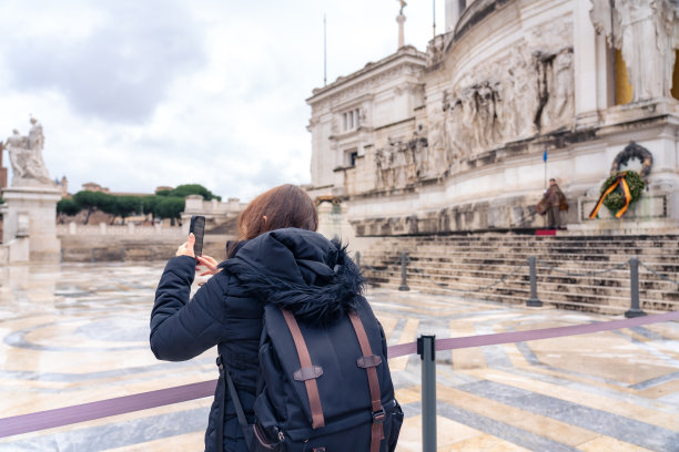 无法辨认的全身拉丁女旅行者，背着背包，在意大利罗马的广场上欣赏着祖国祭坛，享受着令人惊叹的雄伟城市景观图片下载