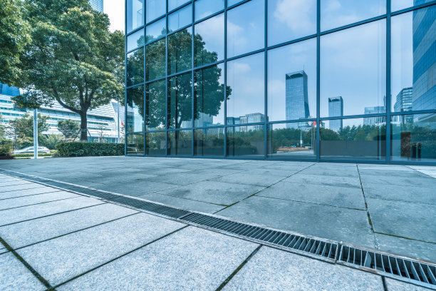 建筑物和干净的道路倒映在玻璃墙上图片下载