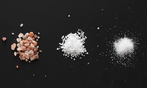 粉红色喜马拉雅盐，课程盐和黑色背景的食盐图片下载