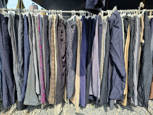 旧裤子挂在衣架上。在泰国的一个二手市场。图片下载