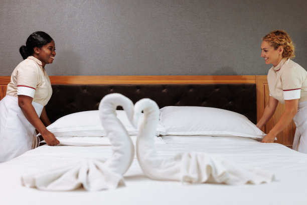 多民族酒店服务员和床上毛巾装饰图片下载