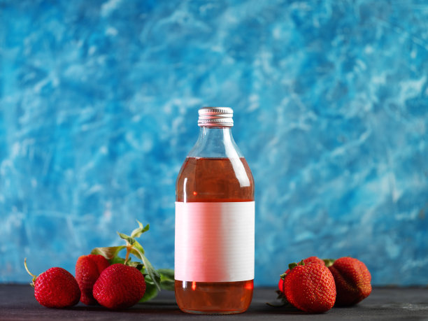 在蓝色背景上制作草莓柠檬水。成熟的草莓图片下载