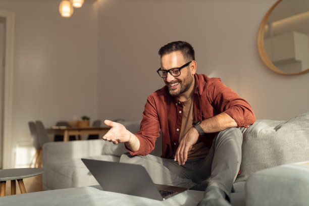 商人和他的同事交谈，在家里开在线会议。图片下载