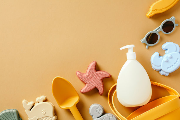 一瓶防晒霜和婴儿太阳镜和沙子玩具的彩色背景。儿童防晒概念。图片下载